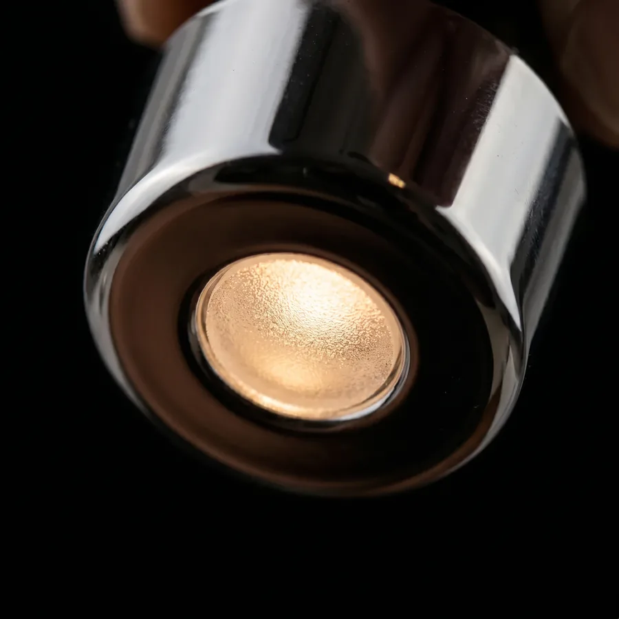 Macro of the warm-white LED recessed behind a frosted lens in the chrome cap